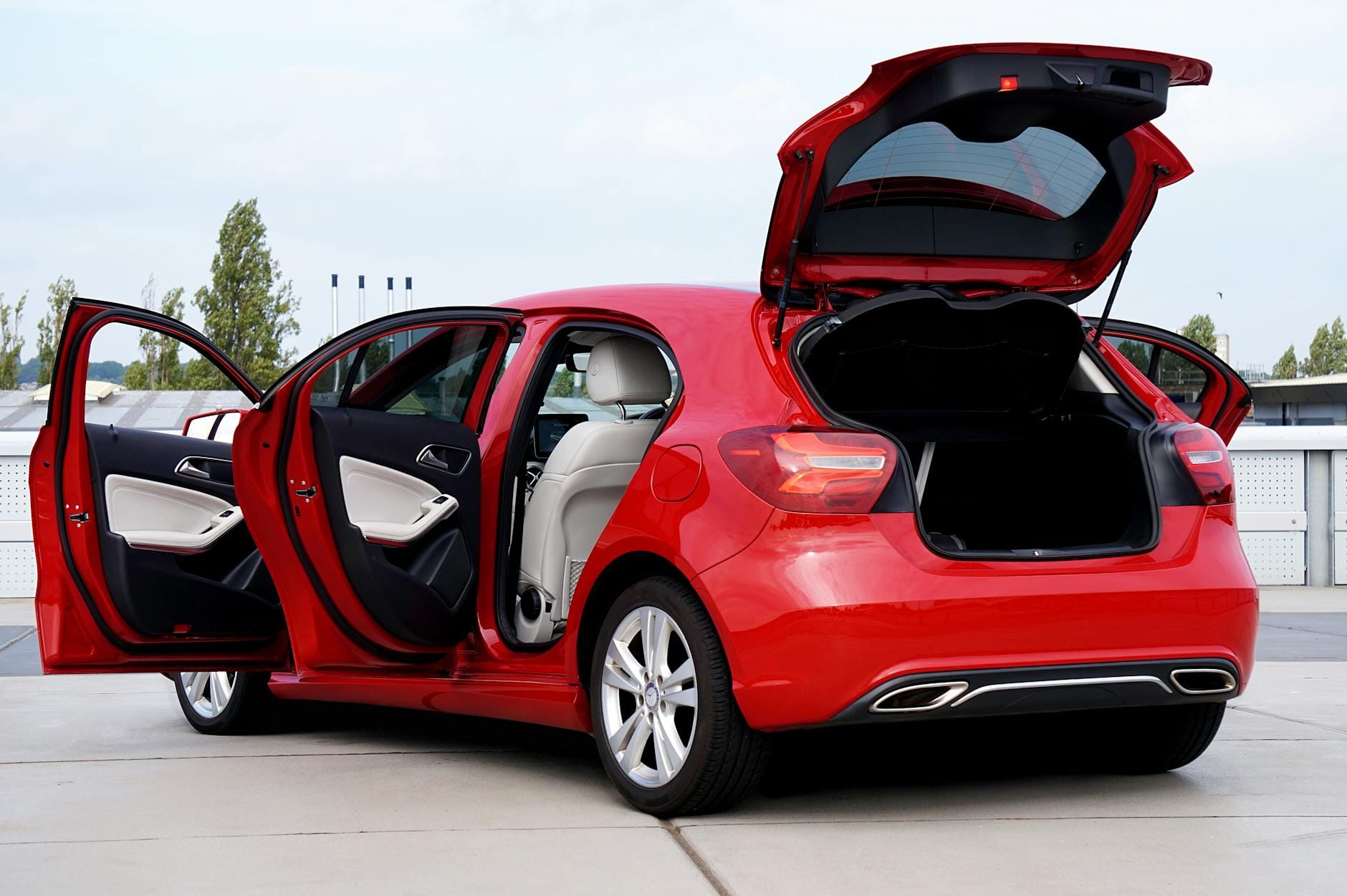 Czerwony hatchback z otwartym bagażnikiem przygotowany do domowego detailingu