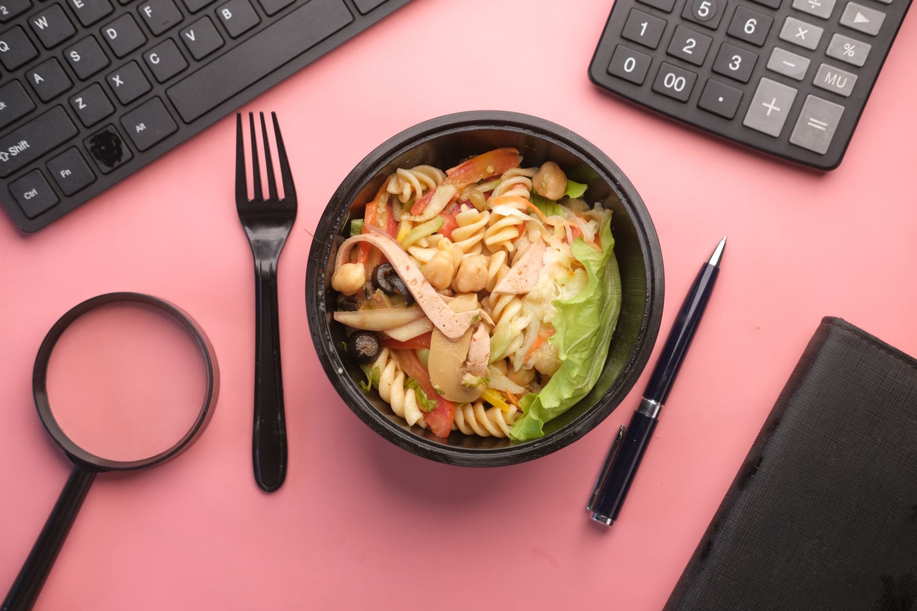 Kolorowa sałatka makaronowa na biurku w biurze jako zdrowy lunch