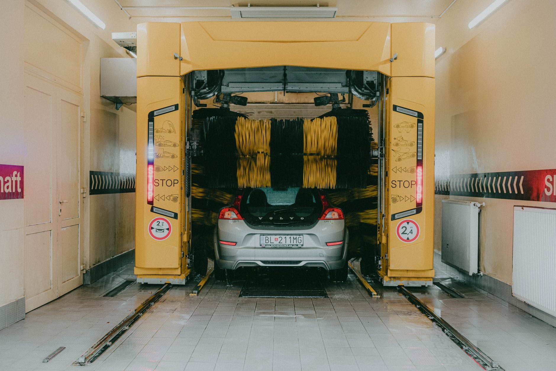Samochód myty w automatycznej myjni pod żółtą bramą
