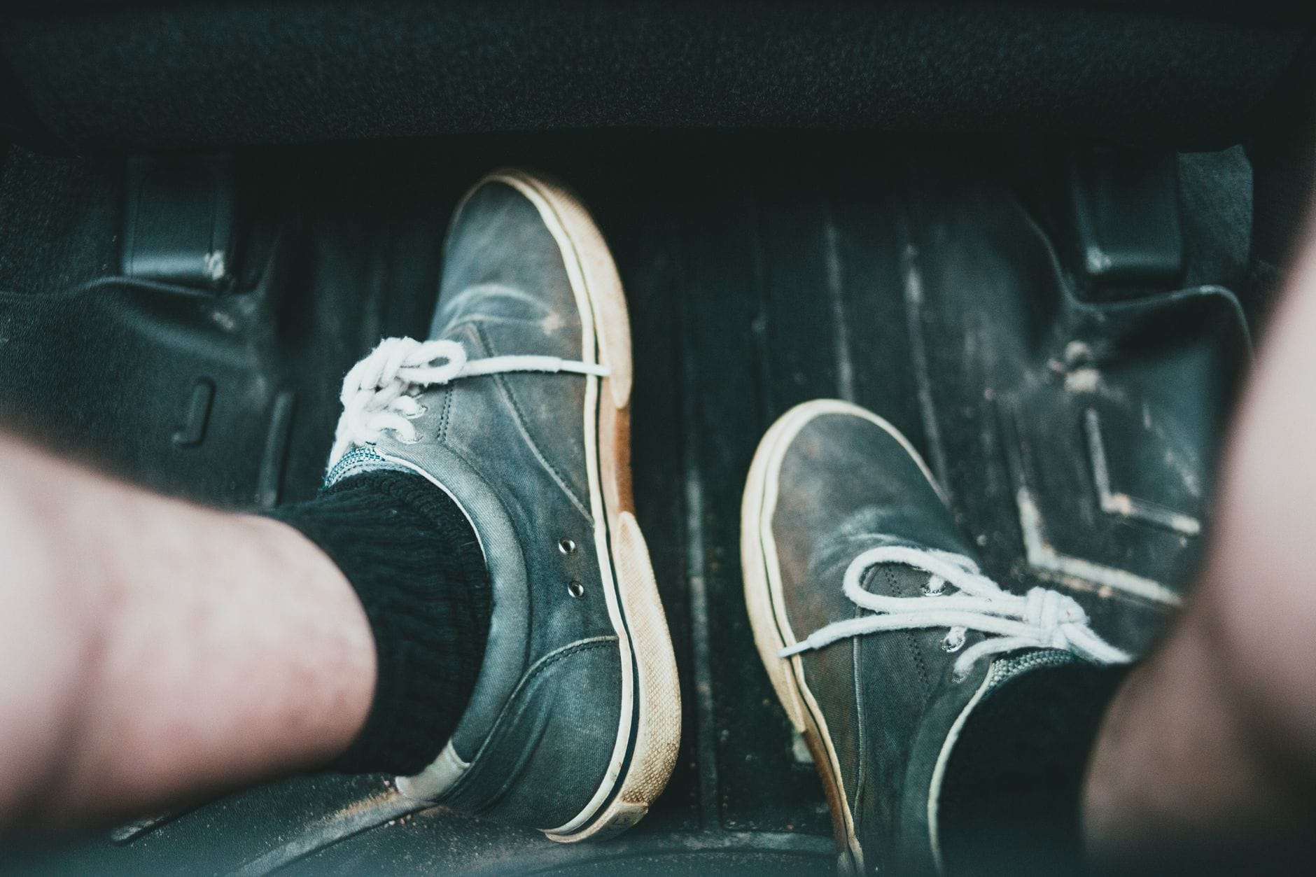 Zbliżenie na sportowe buty stojące na dywaniku samochodowym
